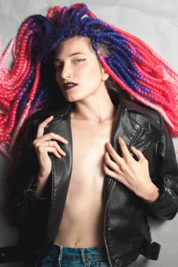 Sahte renk örgü ile alışılmadık bir genç kadın yerde yatıyor