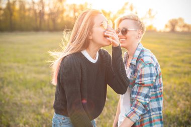 İki güzel genç kadın güneş ışığında açık havada eğleniyor.