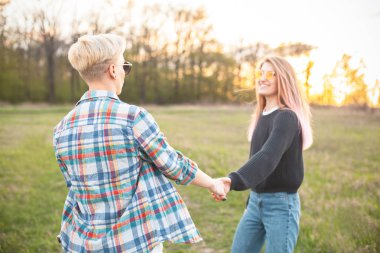 İki çekici genç kadın sahada yürüyor. En iyi dostlar