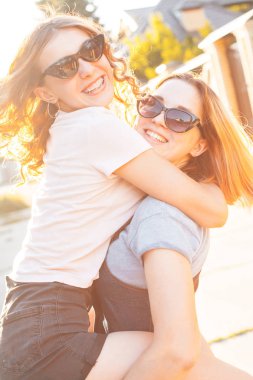 İki yakın arkadaşlarım güneş ışığı altında caddesindeki having fun.