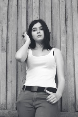 Duvara yakın duran genç kadın. Siyah ve beyaz