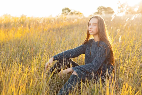 Młoda Kobieta Siedzi Trawie Zachodzie Słońca — Zdjęcie stockowe