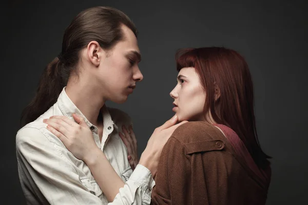 灰色の背景にある若い男性と女性 — ストック写真