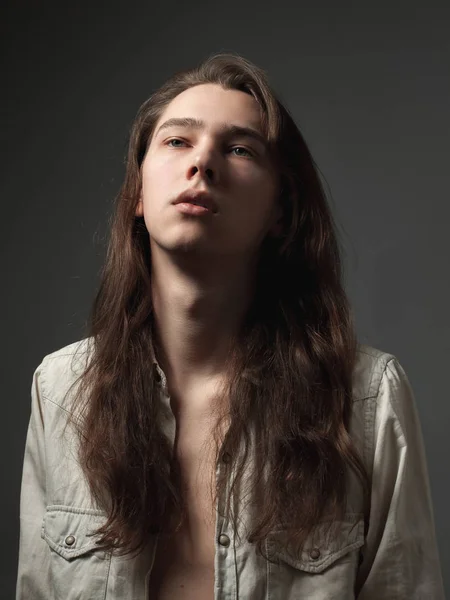 Portrait of the young man with long hair.