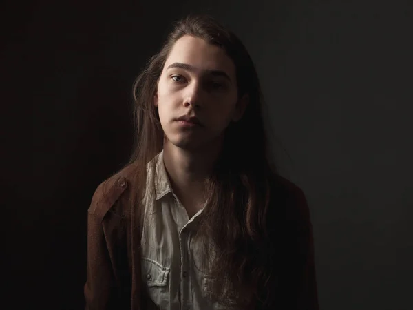 長い髪を持つハンサムな若い男のスタジオの肖像画 ローキー — ストック写真