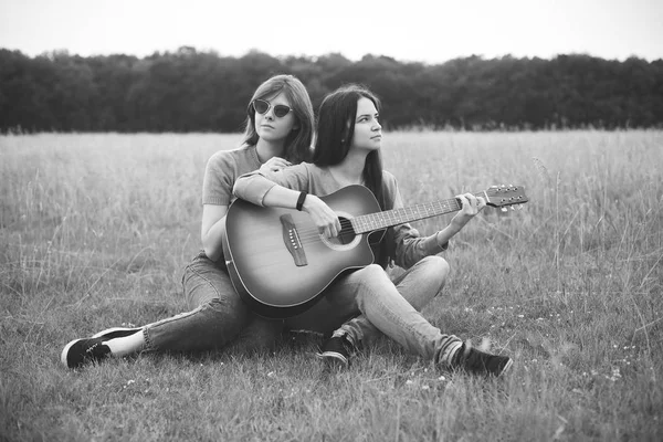 Zwei Mädchen Sitzen Auf Dem Gras Und Spielen Gitarre Schwarz — Stockfoto