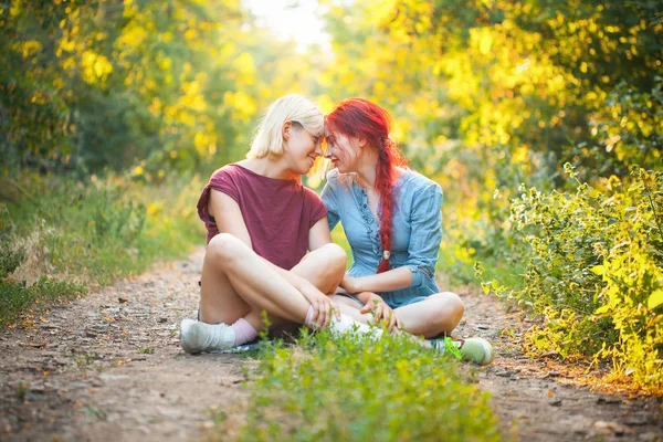 Twee Meisjes Zittend Weg Het Bos Onder Zonlicht — Stockfoto