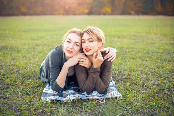 陽気な2人の若い女性が芝生の上で休息している — ストック写真