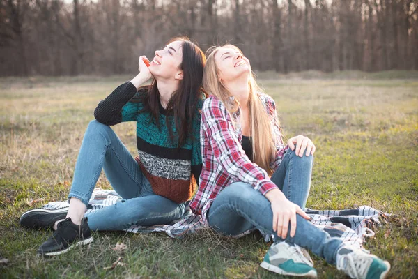两个最好的朋友坐在草地上笑着 — 图库照片