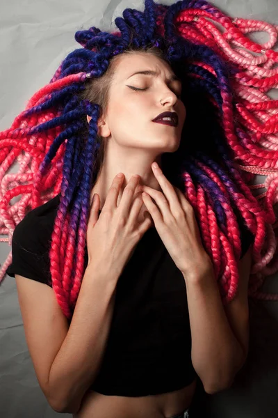 Passionate young woman with unusual haircut lies on the floor