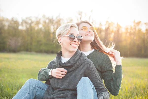 Twee Schattige Jonge Vrouwen Zittend Het Grasveld Onder Zonlicht — Stockfoto