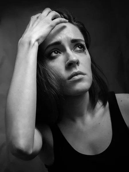 Sad young woman in studio. Black and white.