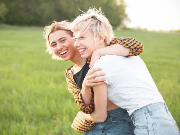 緑のフィールドに楽しみを持っている2人の陽気な若い女性 親友たちです — ストック写真