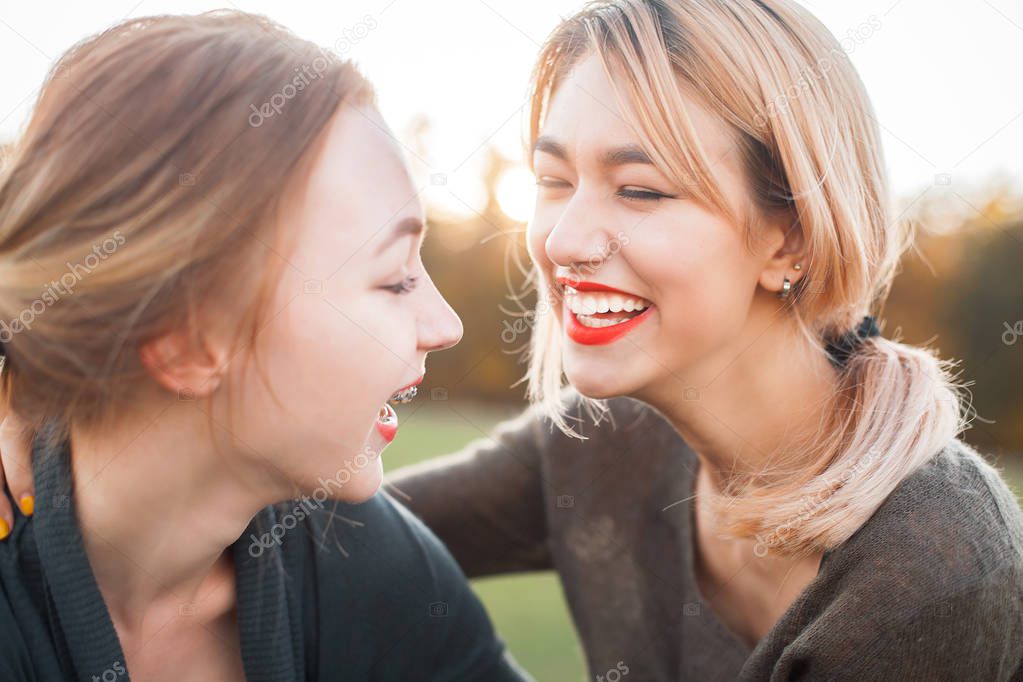 Two young female laughing outdoors. Best friends