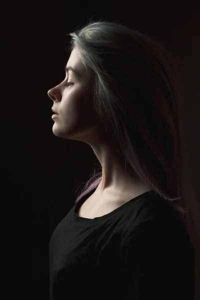 Saçları boyalı genç bir kadın. Profil. Alçak tuş