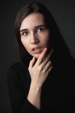 Siyah arka plan üzerinde korkmuş genç kadının portresi.