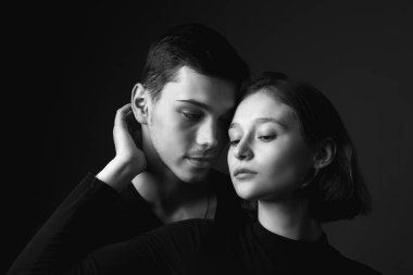 Genç bir kadın ve genç bir adam stüdyoda. Siyah ve beyaz