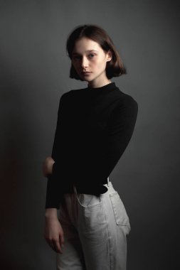 Gri arka planda üzgün genç kadın