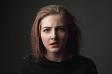 Siyah arka planda şaşkın genç kadın