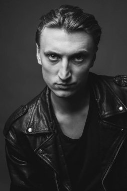 Deri ceketli ciddi genç adamın portresi. Siyah ve beyaz. Yakın çekim.