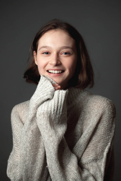 Portrait of a laughing young woman on the gray background