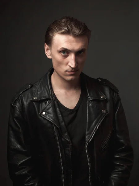 Portrait of the serious handsome young man in leather jacket.