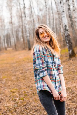 Huş bahçesinde yürüyen mutlu genç kadın