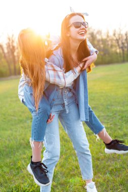 İki kız açık havada eğleniyor. En iyi dostlar