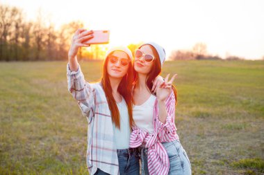 Gün batımında selfie çeken iki kız. En iyi dostlar