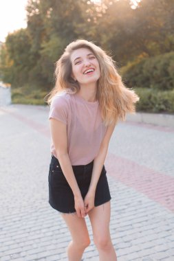 Güzel genç kadın sokakta yürüyüş ve gülüyor.