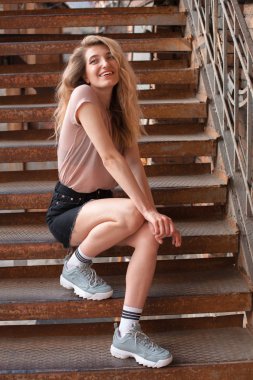 basamaklarında oturan genç kadın.