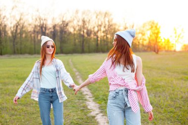 Gün batımında açık havada yürüyen iki kız