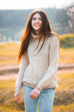 Genç bir kadın ormanda yürüyor.