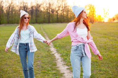 Gün batımında açık havada yürüyen iki kız