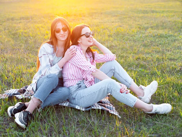 Δύο Κορίτσια Κάθονται Στο Γρασίδι Ηλιοβασίλεμα Καλύτεροι Φίλοι — Φωτογραφία Αρχείου