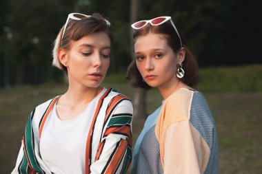 İki güzel genç kadın akşam şehirde birlikte ayakta.