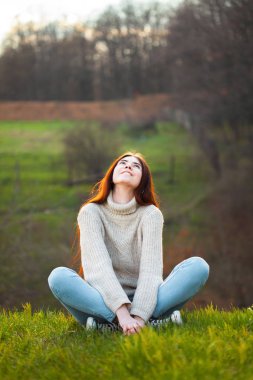 Tepede oturan neşeli genç kadın