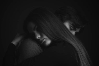 Stüdyoda kucaklaşan genç ve güzel bir çift. Siyah ve beyaz. Kapat.