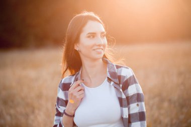 Gün batımında dışarıda gülümseyen genç bir kadın. İşaret fişeği