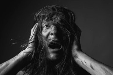 Uzun saçlı, kurum içinde korkmuş bir gencin portresi..