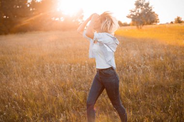 Gün batımında dışarıda yürüyen genç bir kadın. İşaret fişeği
