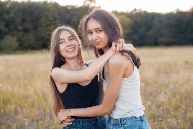 İki genç kadın sarılma ve açık havada eğleniyor. En iyi dostlar