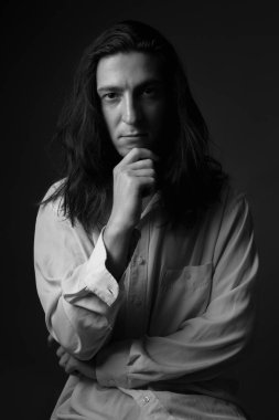Uzun saçlı bir adamın stüdyo portresi. Siyah ve beyaz