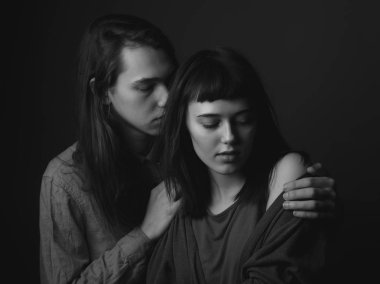 Siyah arka planda genç bir çift. Alçakgönüllülük. Siyah ve beyaz