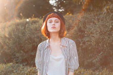 Genç bir kadın gün ışığında dışarıda yürüyor..