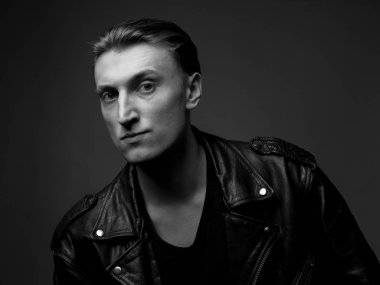 Deri ceketli ciddi bir adam. Stüdyo portresi. Siyah ve beyaz