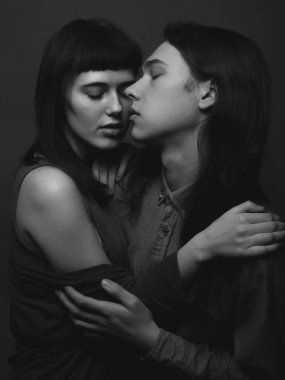 Genç bir adam ve genç bir kadın sarılıyor. Siyah ve beyaz