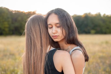 Sahada sarılan iki neşeli genç kadın, en iyi arkadaşlar.