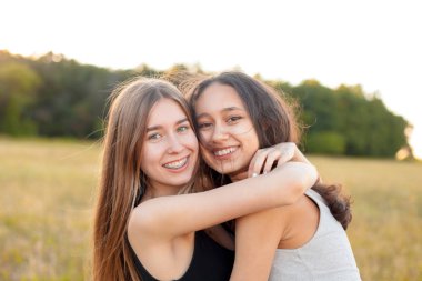Dışarıda kucaklaşan iki güzel genç kadın, en iyi arkadaşlar.