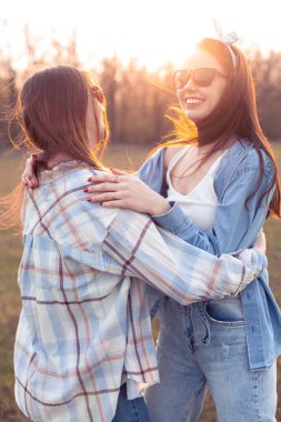 Eğlenceli açık havada günbatımında iki genç kadın. En iyi dostlar